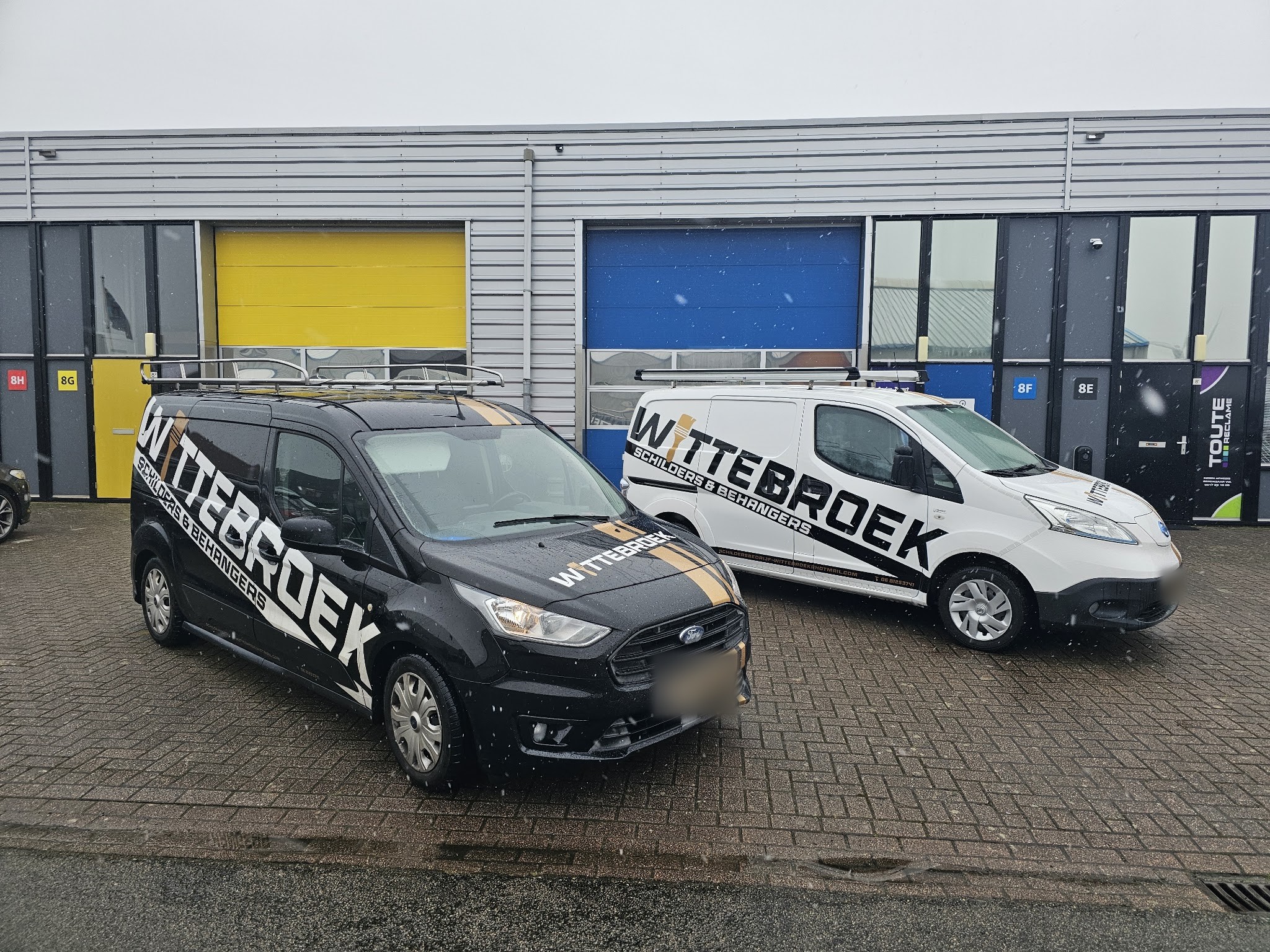 Een zwarte en een witte bus van Wittebroek voor het bedrijfspand aan de Kiehoek